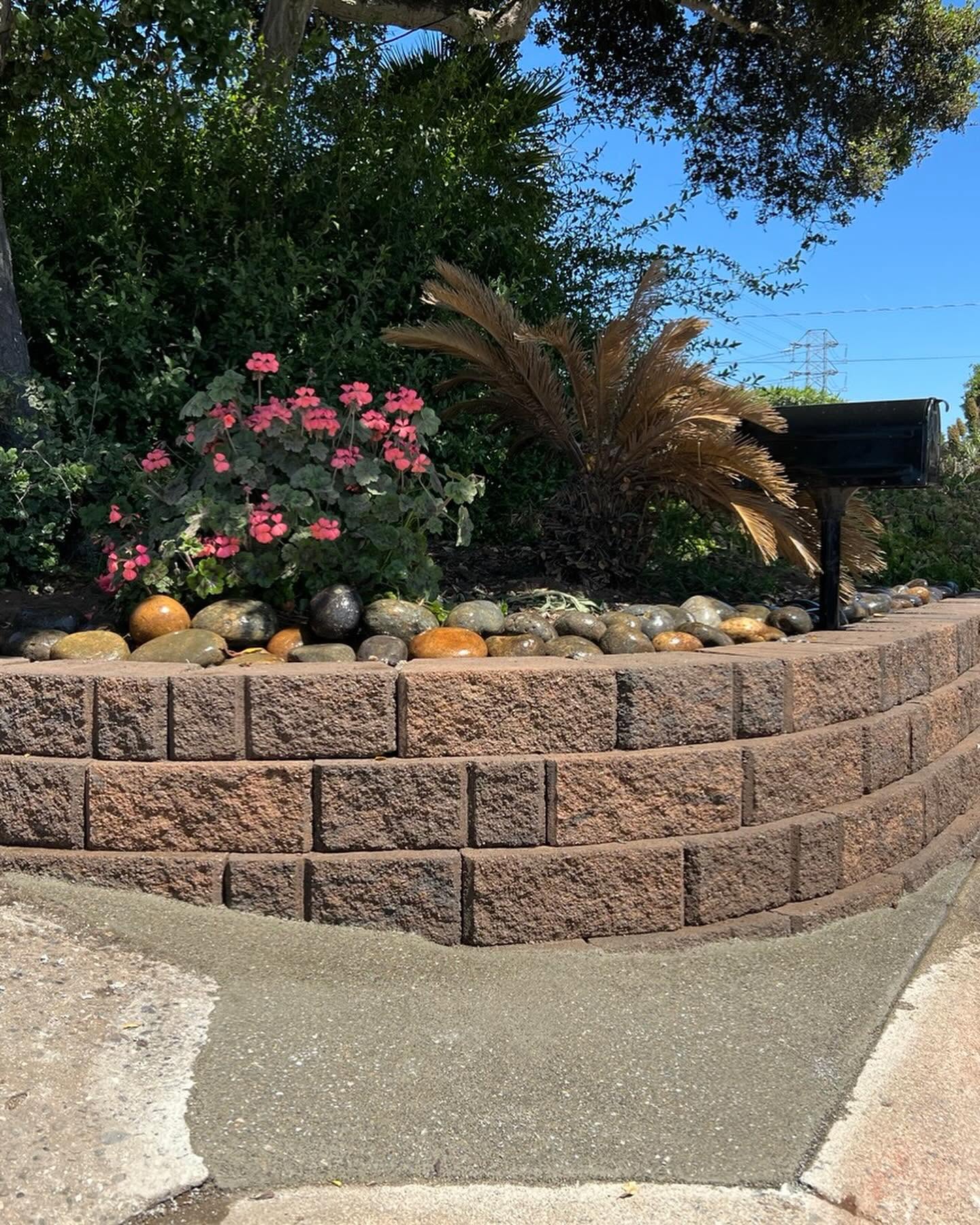 Curved retaining wall with flowers and mailbox